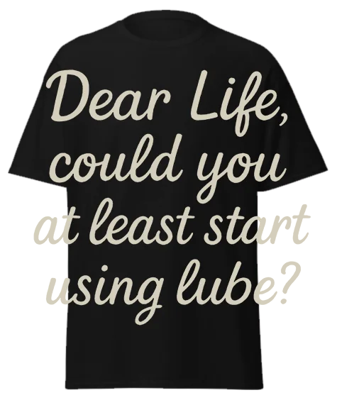 Black unisex t-shirt with off-white script text reading "Dear Life, could you at least start using lube?" – funny sarcastic graphic tee